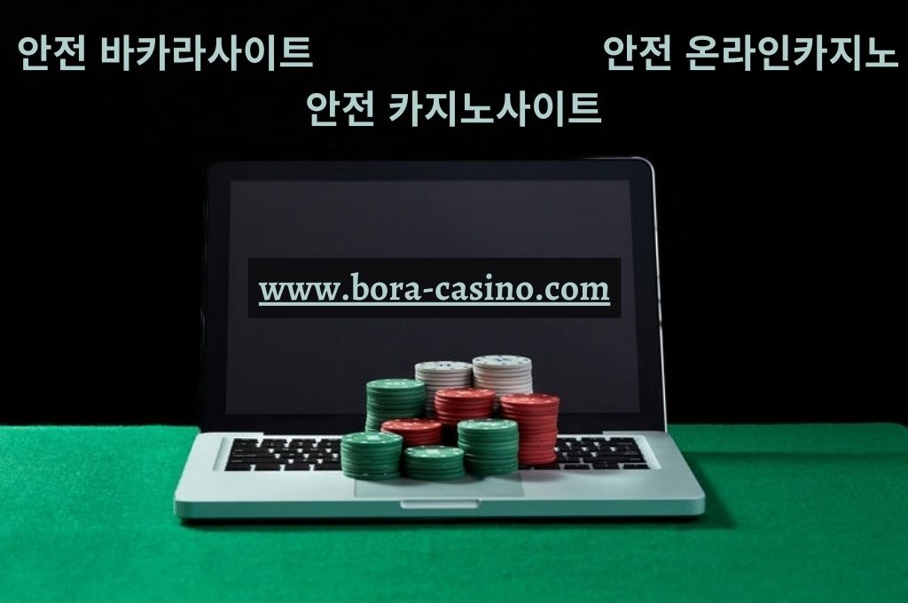 Casino chips on laptop keyboard at the green table and plain black background